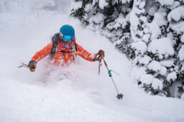 A skier in an orange jacket at White Grizzly Cat Skiing along the powder highway.