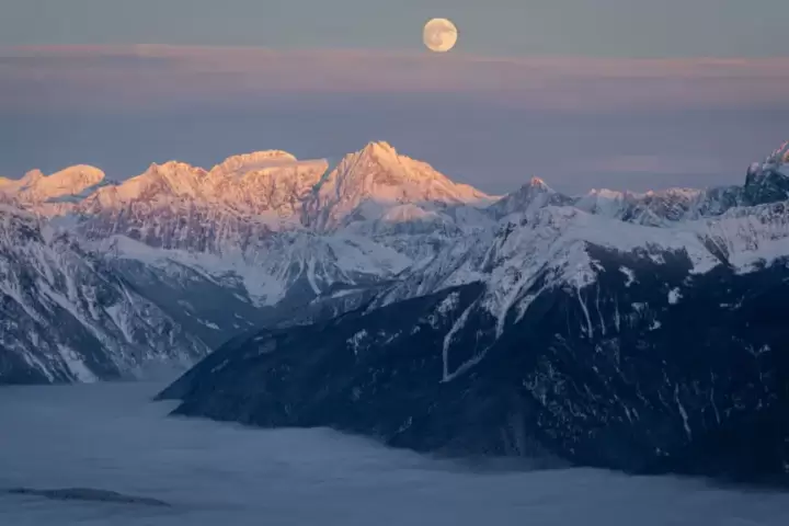 The sun, the moon, the majestic terrain: A serene evening view promises endless lines and unmatched cat skiing adventures for the next day at White Grizzly in BC, the best in North America.