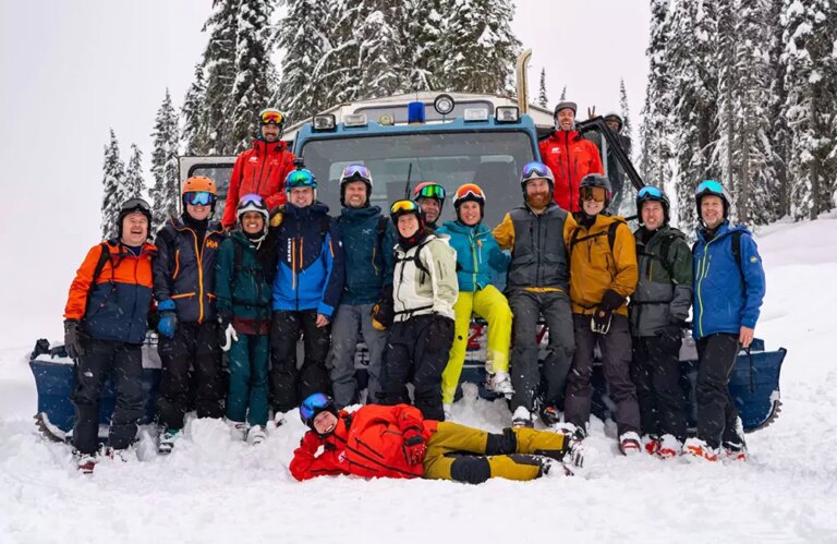Team photo of cat skiing guides at white grizzly in front of the cat ski