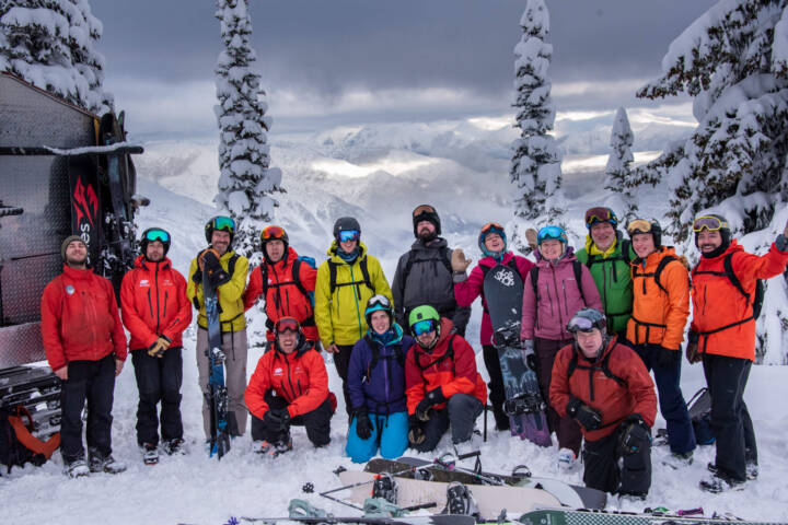 Group of elated guests convening for a picture, capturing their excitement after an incredible day of deep snow lines at White Grizzly cat skiing in BC, Canada.