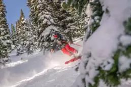 Energetically hopping through sun-kissed powder, a testament to the exhilarating cat skiing adventures at White Grizzly in BC, the best in North America.