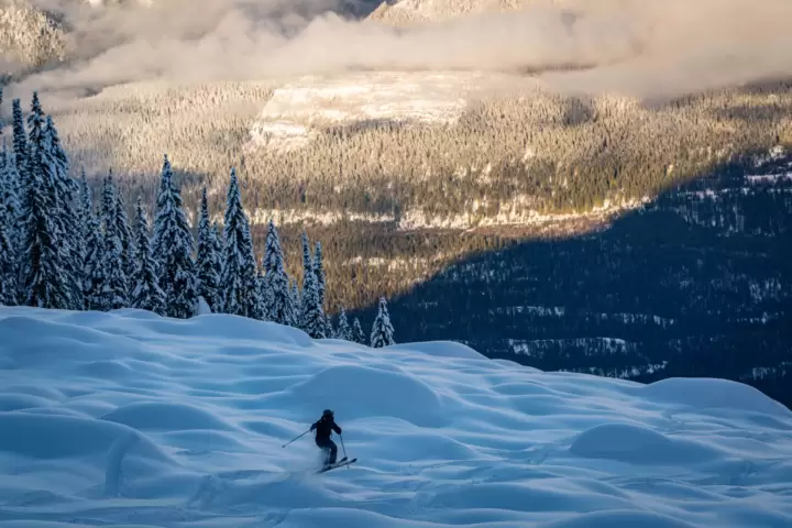 Energetically hopping through sun-kissed powder, a testament to the exhilarating cat skiing adventures at White Grizzly in BC, the best in North America.